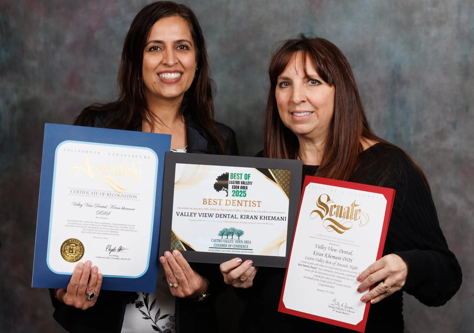 Two dental professionals display 2025 awards for best dentist in Naperville, Illinois.